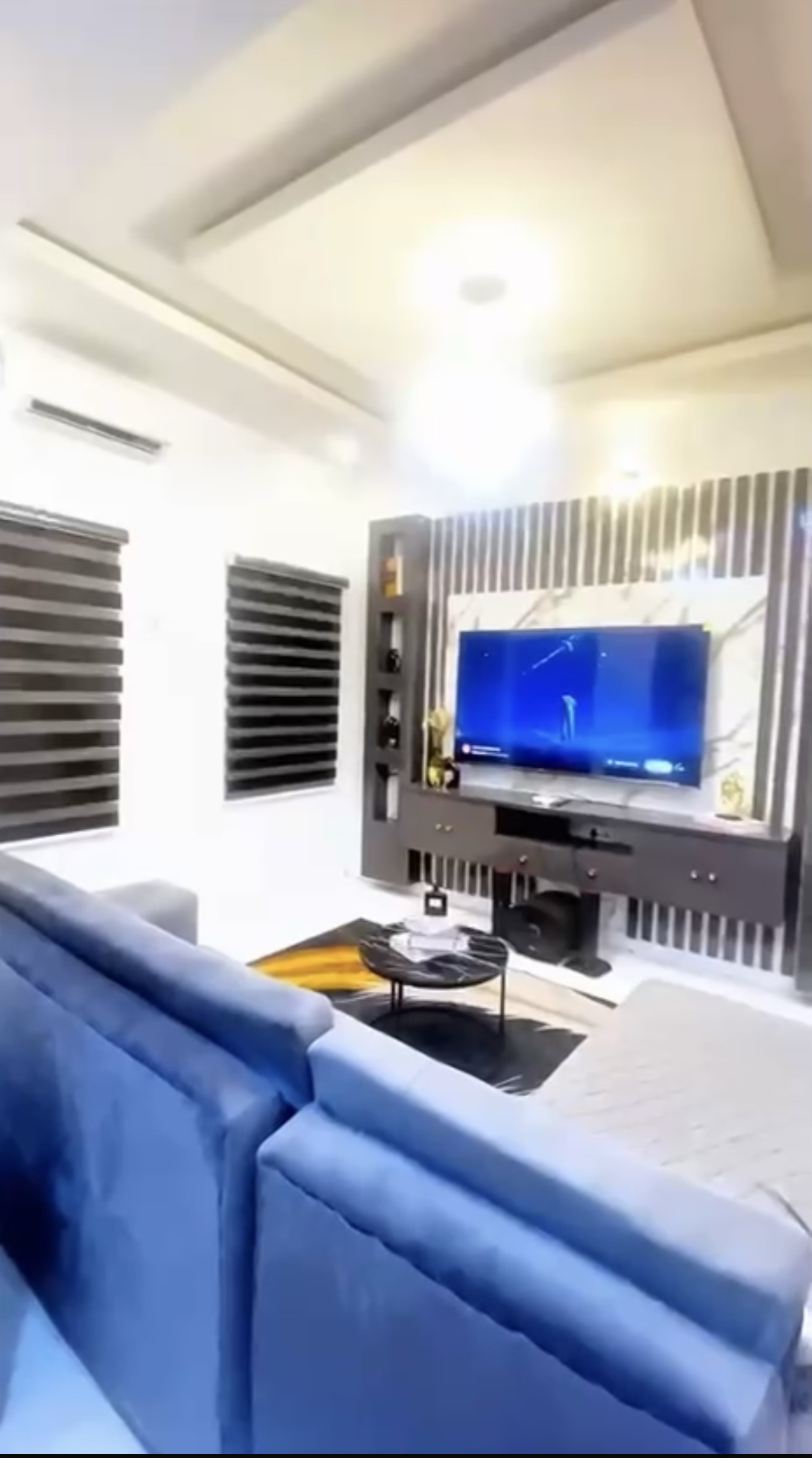 Laimon living room with blue seating and a wall-mounted television